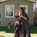 Mom, Julie blowing bubbles with autistic daughter
