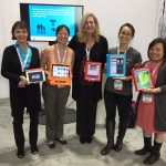 Five women standing holding iPads