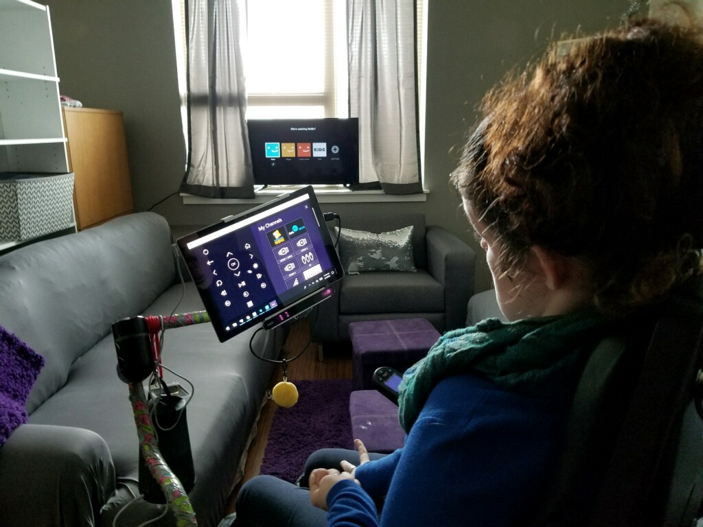 Young lady in wheelchair using attached mobile device