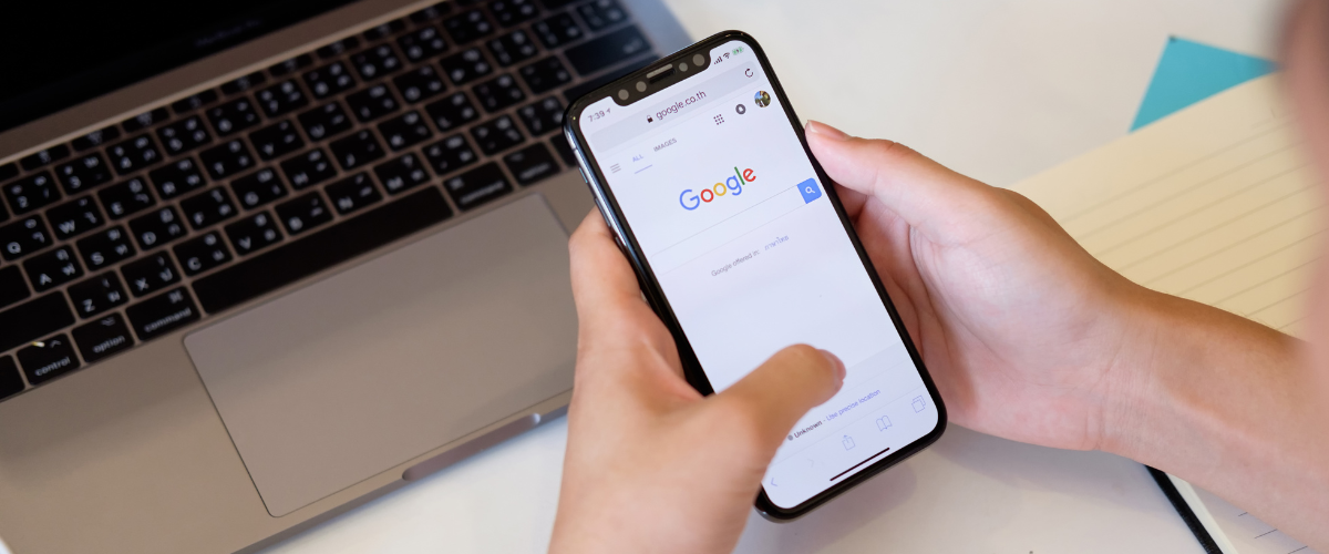 hand holding phone with google homepage displayed