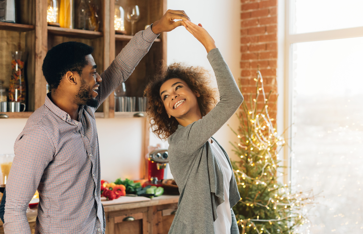 couple dancing in front of Christmas tree