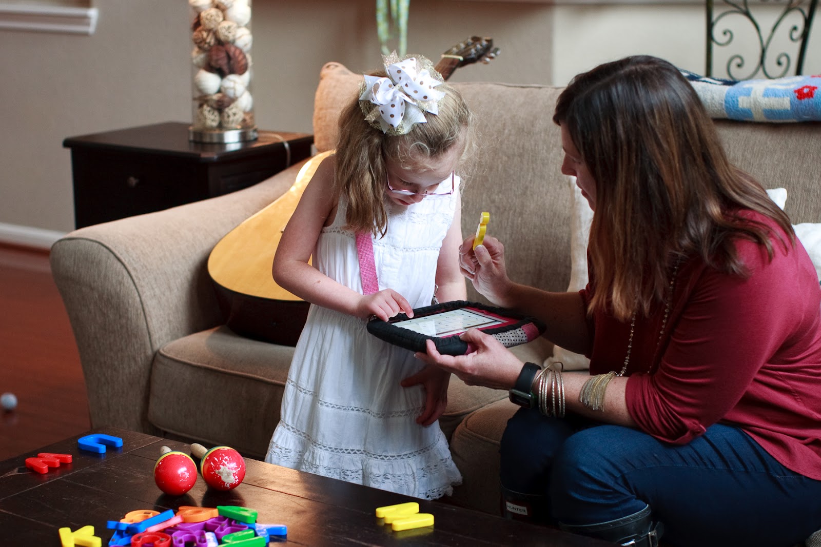 young girl using ipad with mom