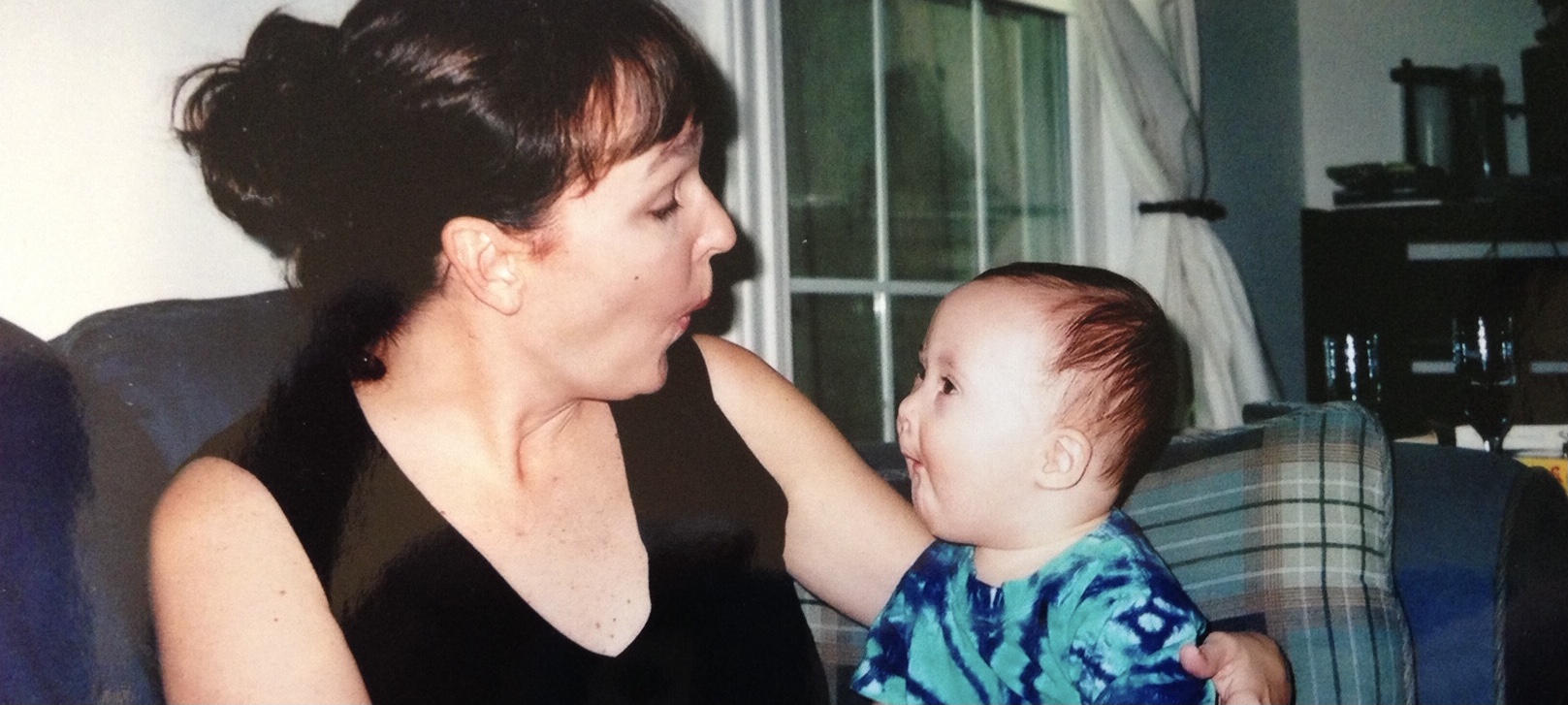 White mother with infant son with Down syndrome on her lap