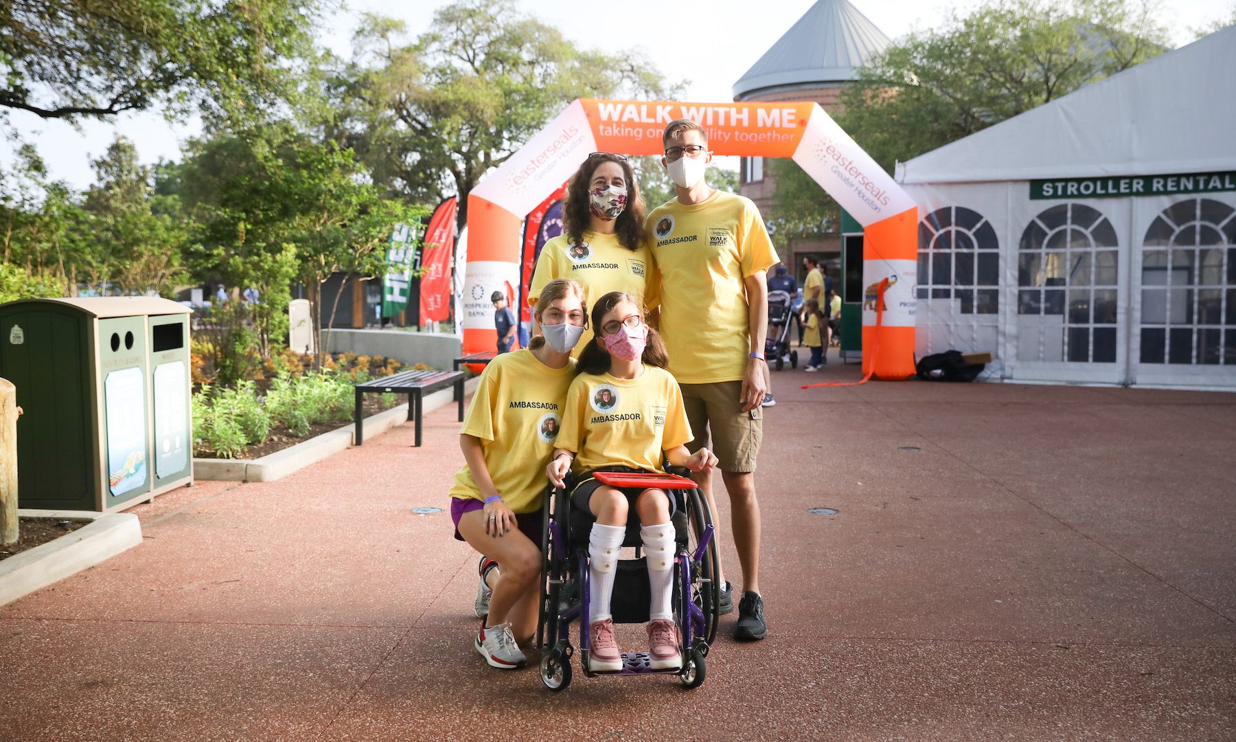 girl with in wheelchair holding ipad with family