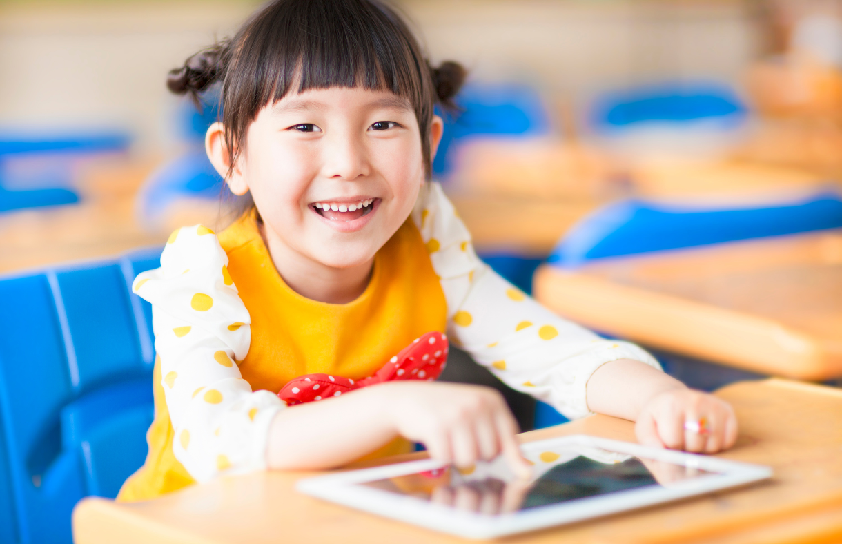 girl in orange shirt using ipad