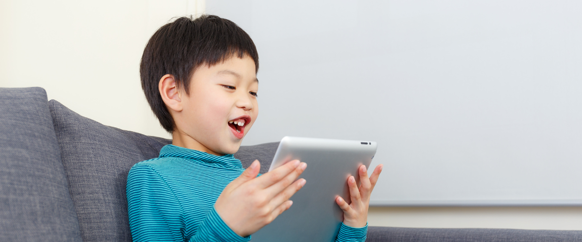 boy holding ipad on couch