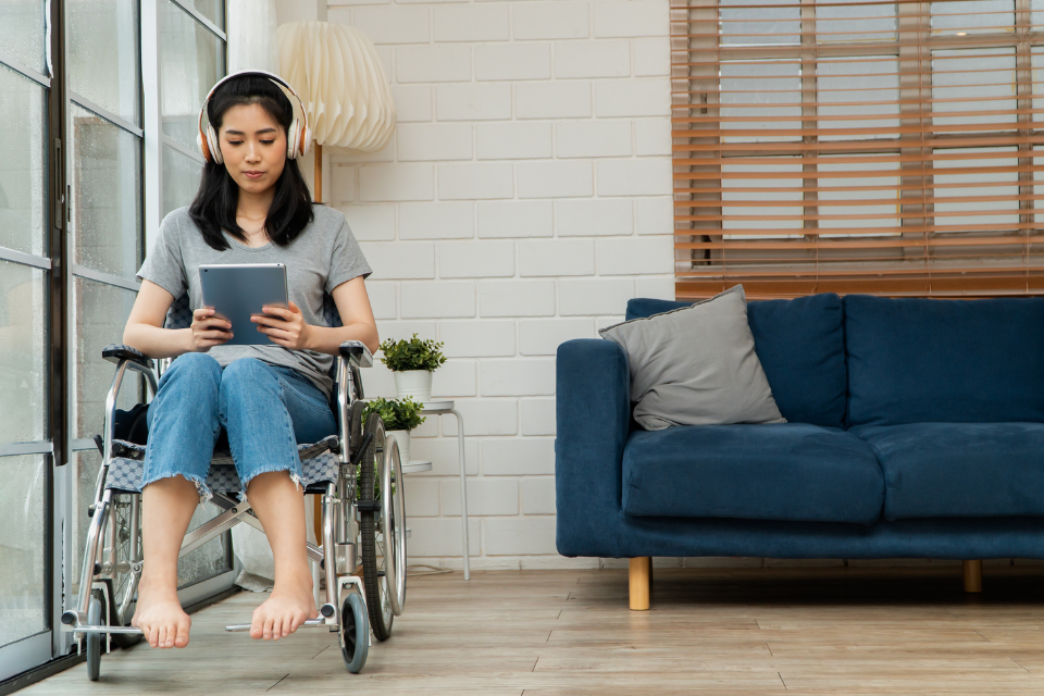 teen girl holding mobile device in wheelchair