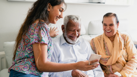 young adult helping older adult with technology
