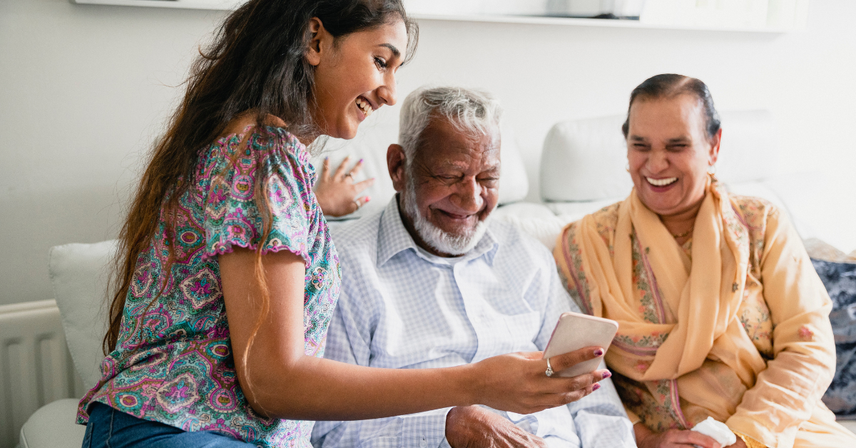 young adult helping older adult with technology