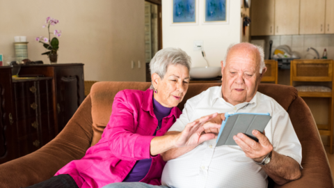 older adult couple looking at ipad