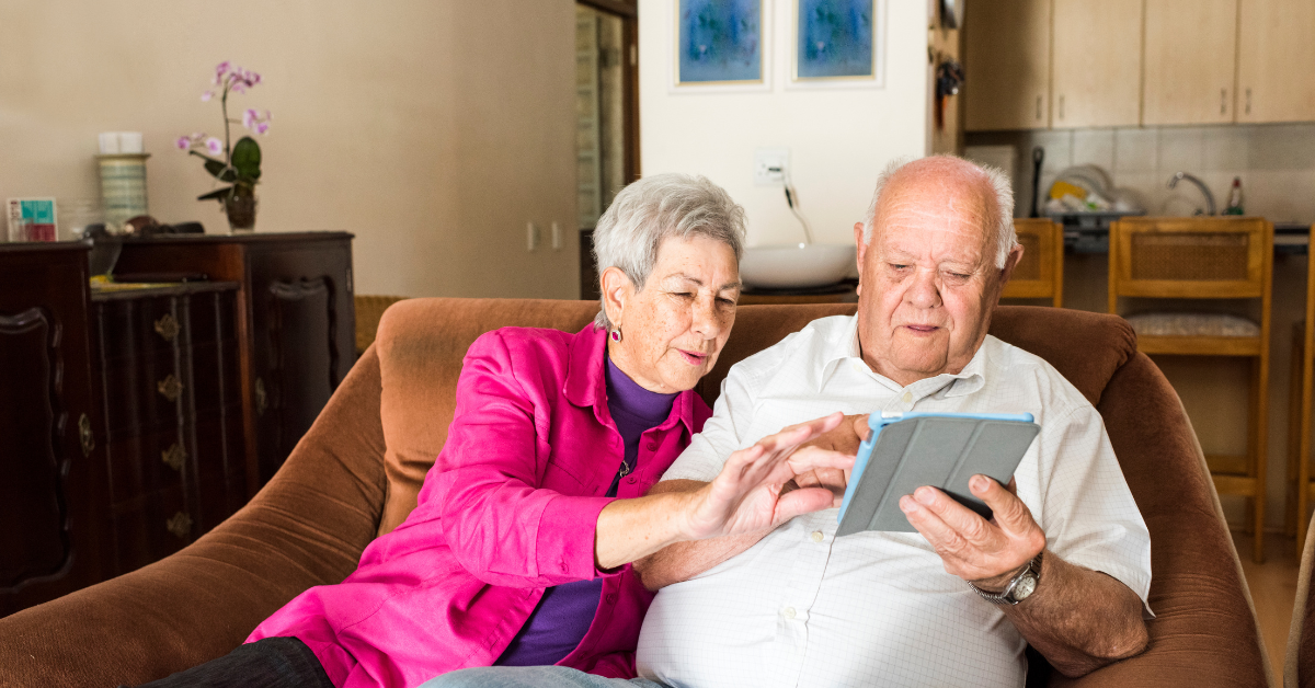 older adult couple looking at ipad