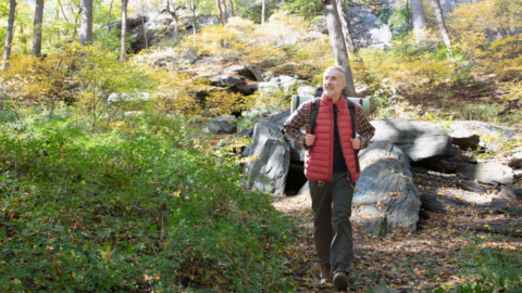 older man walking in forest