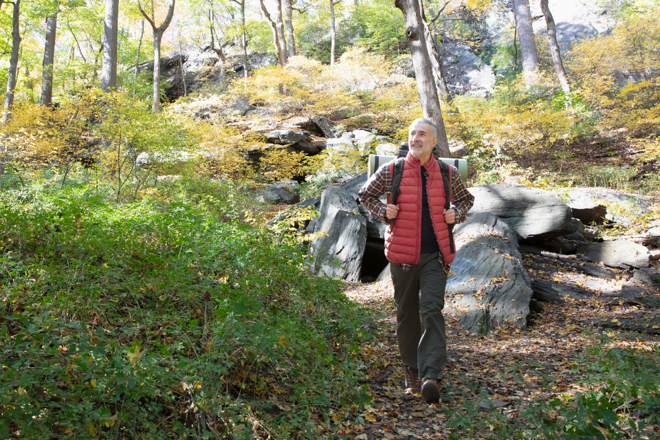 older man walking in forest
