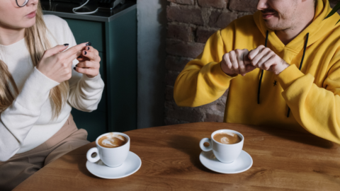 couple having coffee communicating with sign language