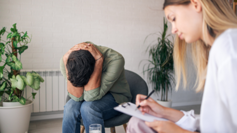 man with head down in hands meeting with provider