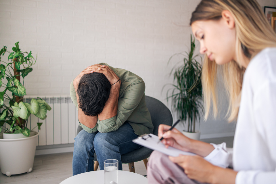 man with head down in hands meeting with provider
