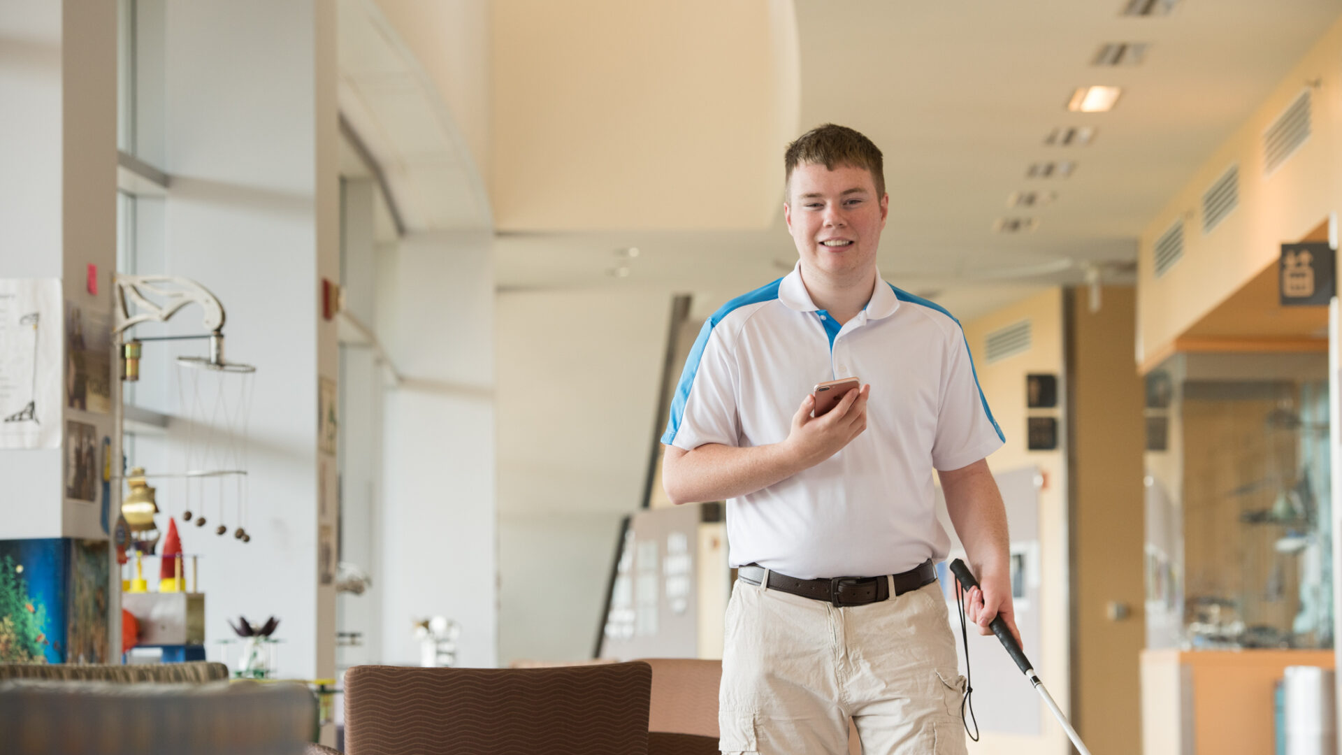 Man walking using iphone with white cane in hand