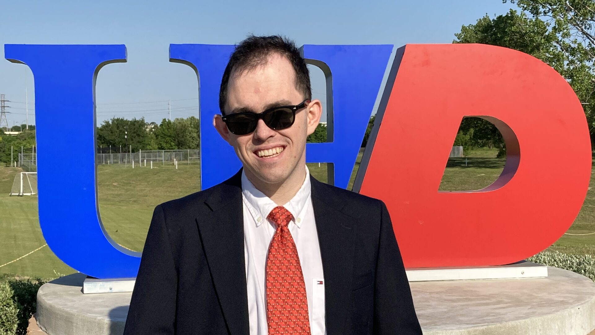 smiling man in suit standing outside