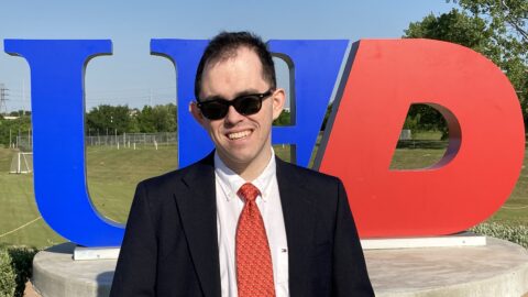 smiling man in suit standing outside