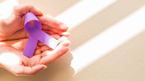 purple epilepsy ribbon in hands