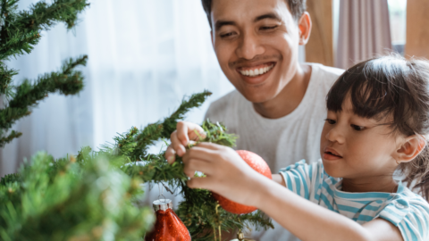dad and daughter decorating christmas tree