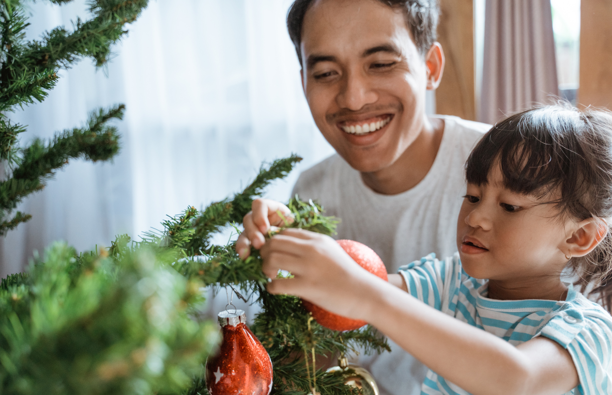 dad and daughter decorating christmas tree