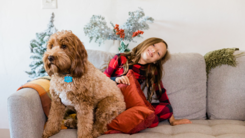 girl sitting with dog on couch