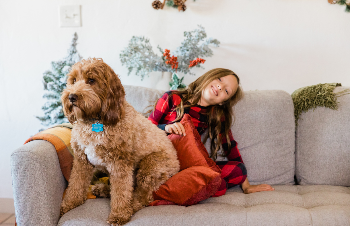 girl sitting with dog on couch