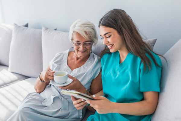 young nurse assisting older female adult