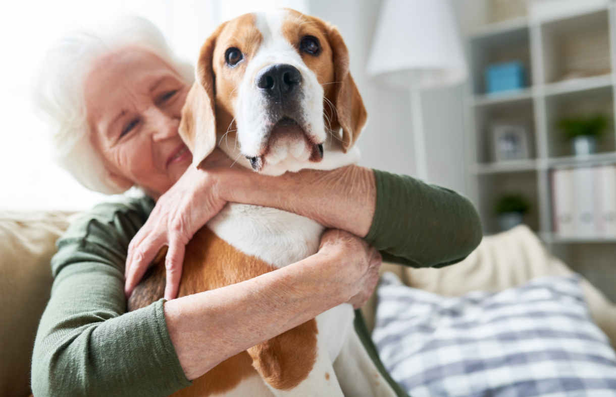 older female adult hugging dog