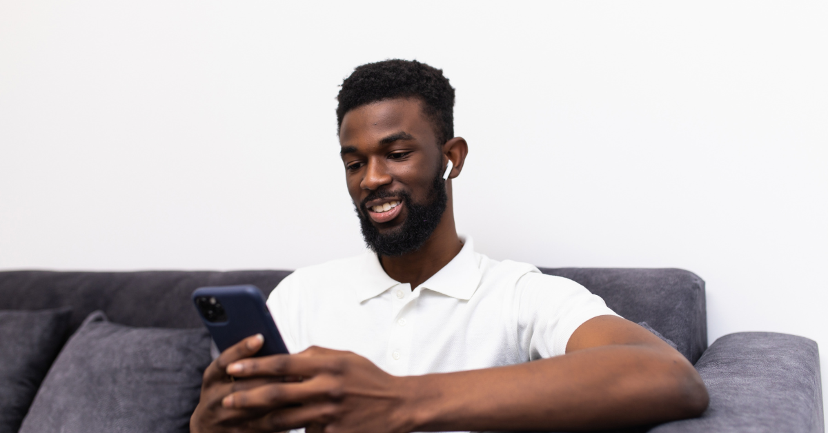 man looking at phone with airpods in ears