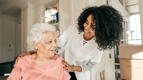 older adult female being assisted by a young female nurse