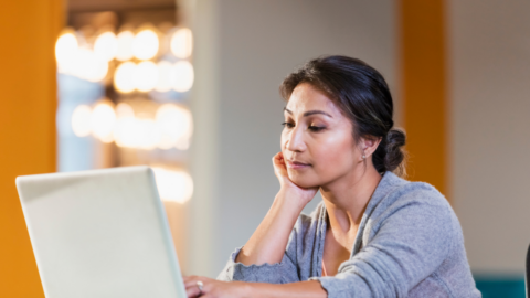 young adult woman looking at laptop