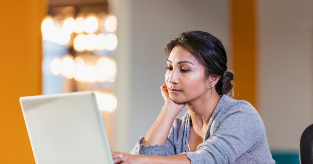 young adult woman looking at laptop