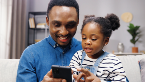 dad and daughter looking at phone together