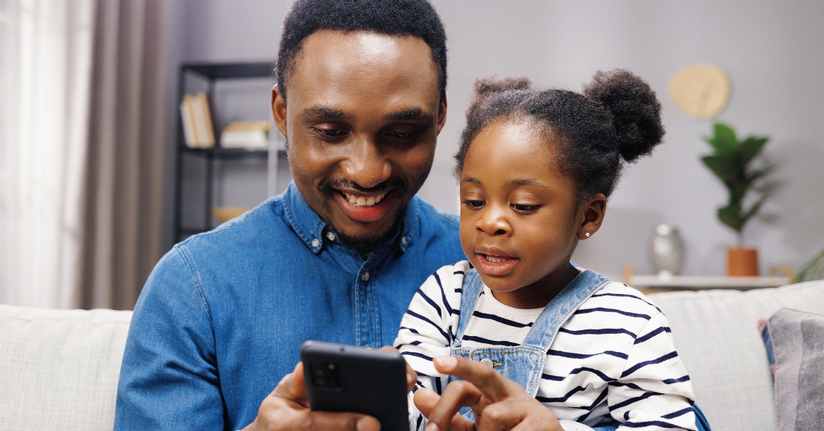 dad and daughter looking at phone together