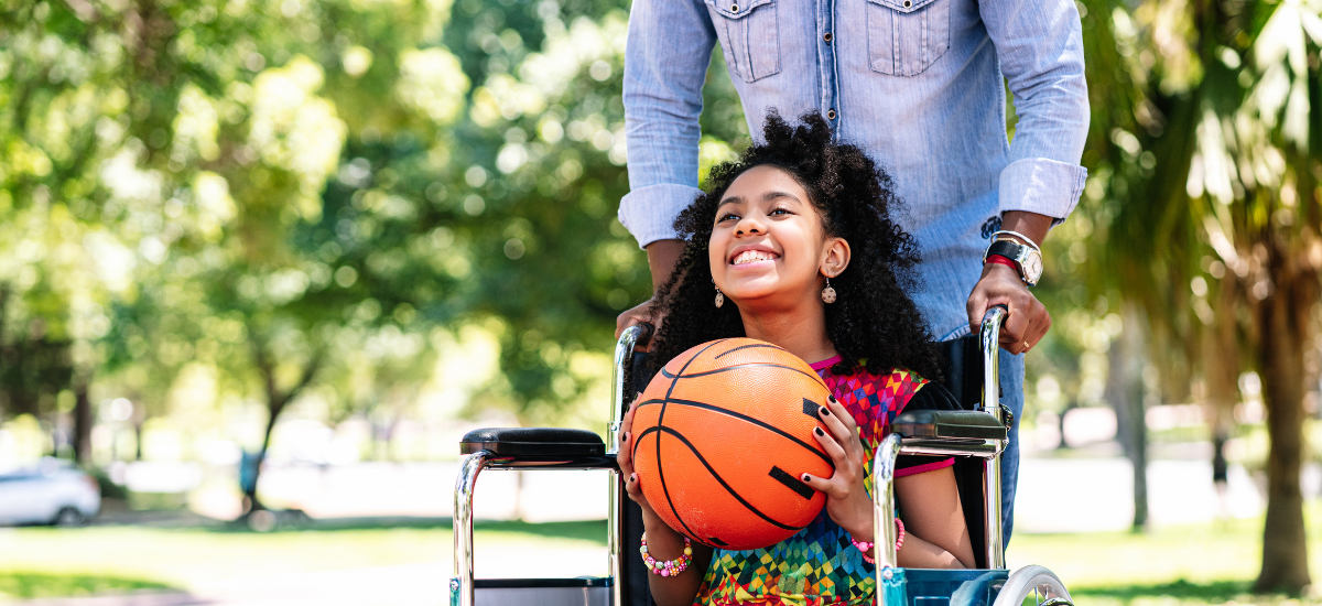 girl in wheelchair holding basketball