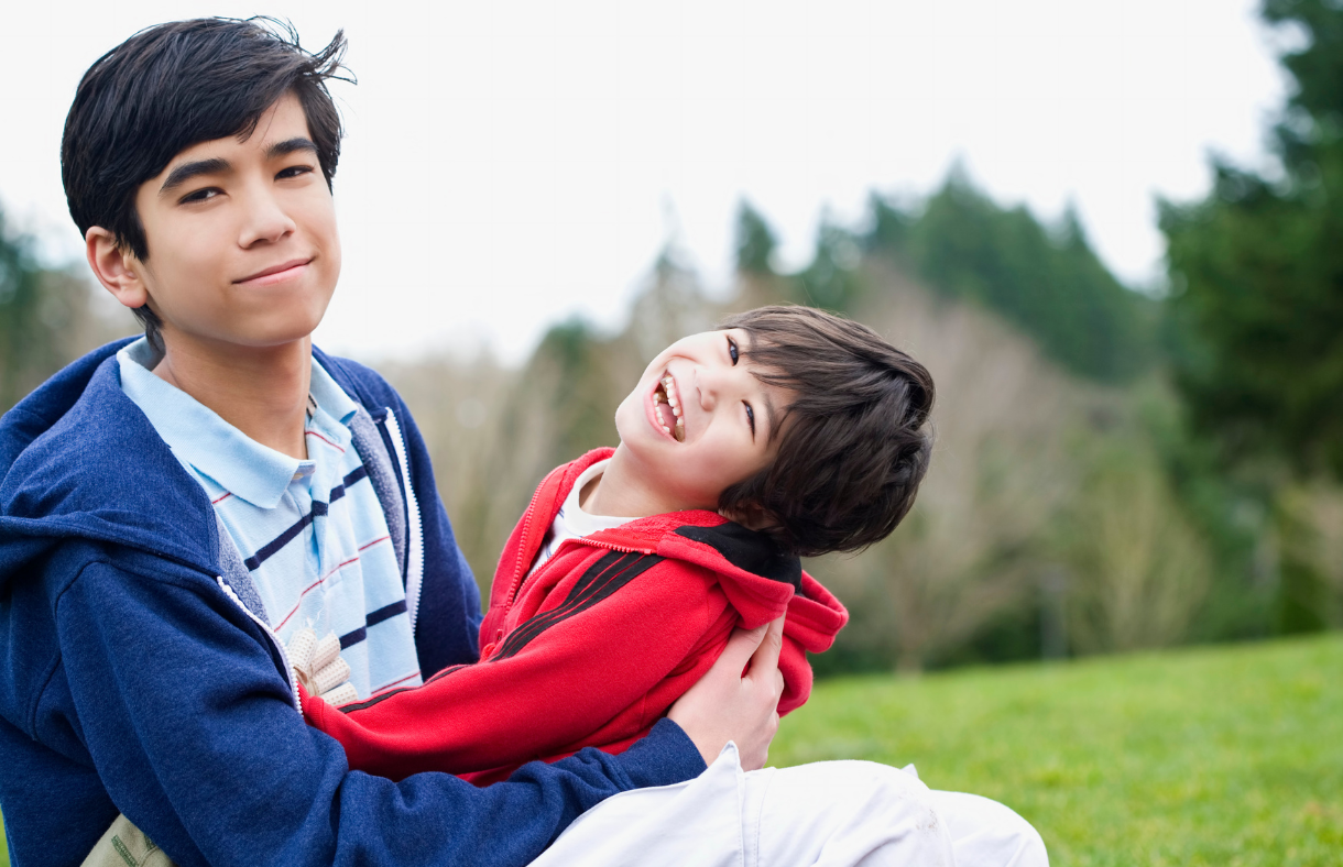 older and younger brother smiling for camera