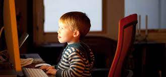 Child sitting in front of desktop computer