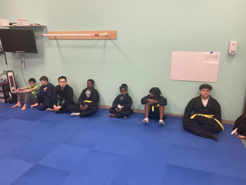 ESGH "karate kids" seated along classroom wall