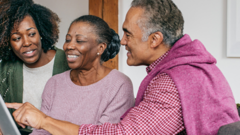 older adult woman being helped with her ipad by lady and man