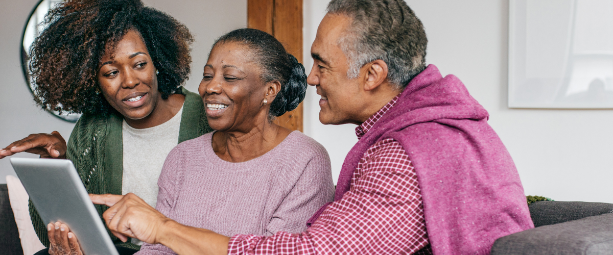 older adult woman being helped with her ipad by lady and man