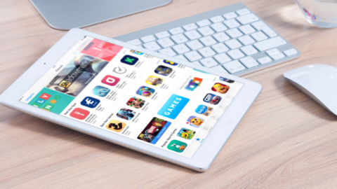 ipad laying on desk with app store displayed on screen