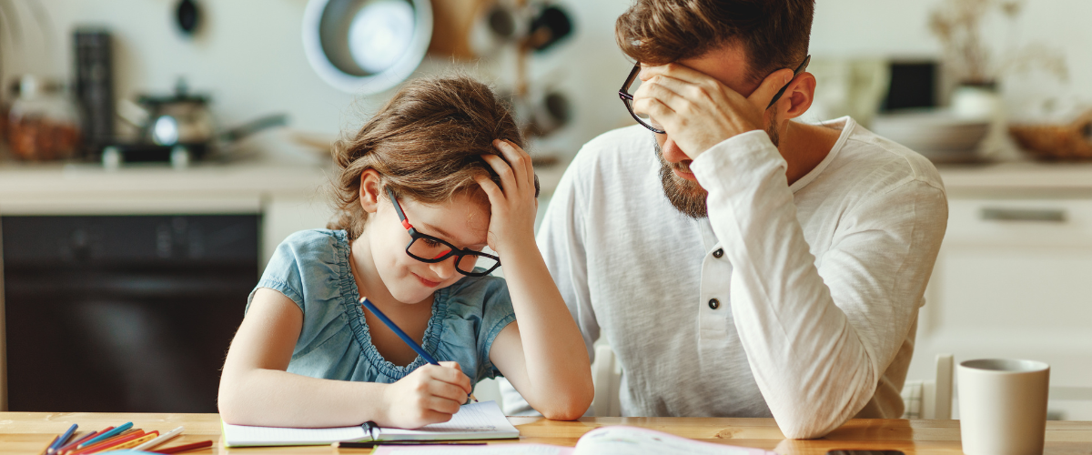 dad helping young daughter with homework