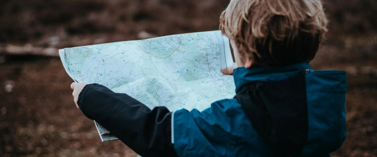 boy looking at paper map