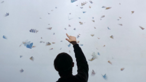 young man pointing up in front of virtual screen