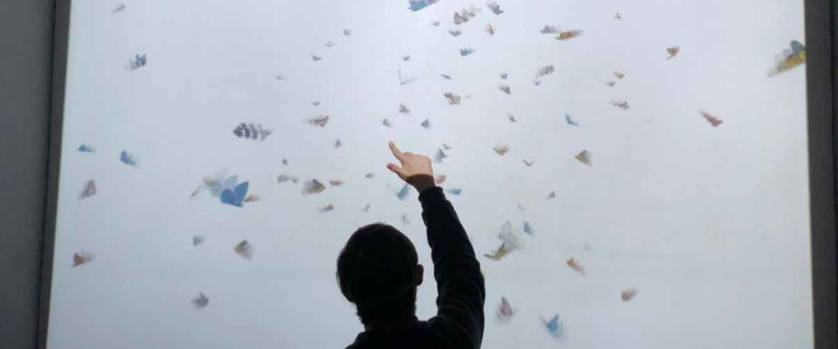 young man pointing up in front of virtual screen