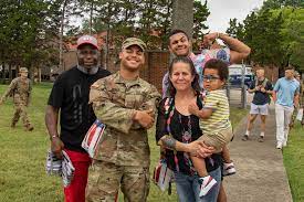 Multiple generations of military family posing in a campground setting