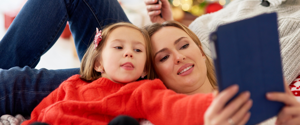 young girl and mom looking at ipad together