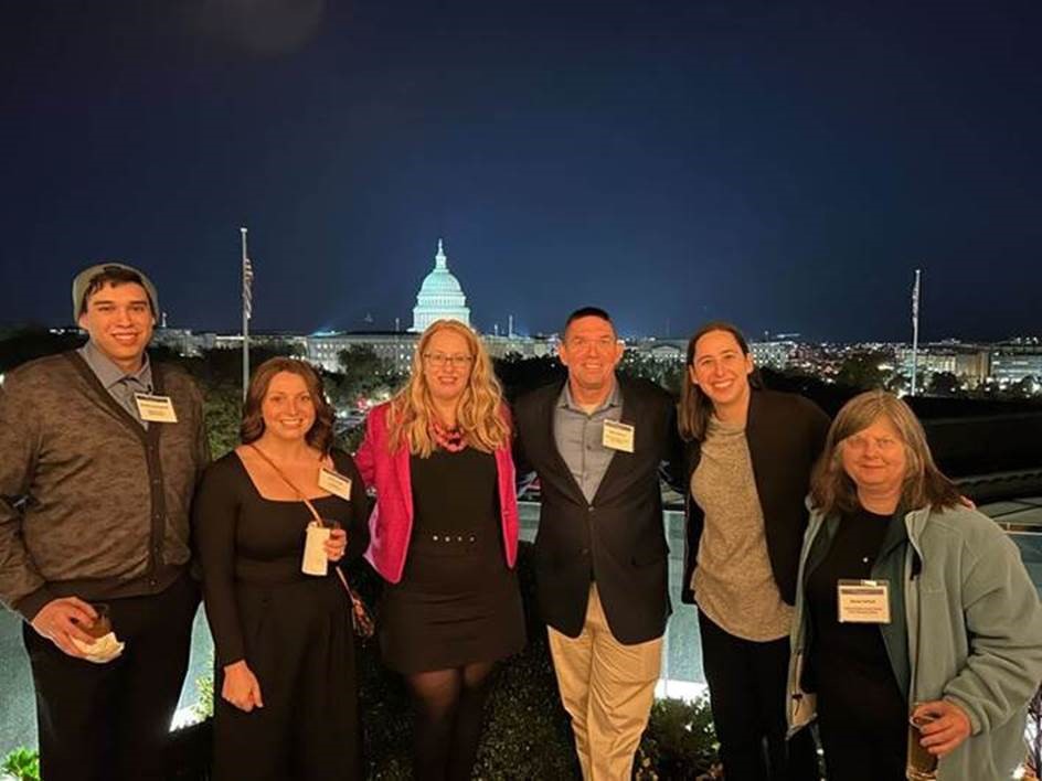 Walter Prescher with other Connect20 attendees, in night shot with U.S. Capitol in the background.